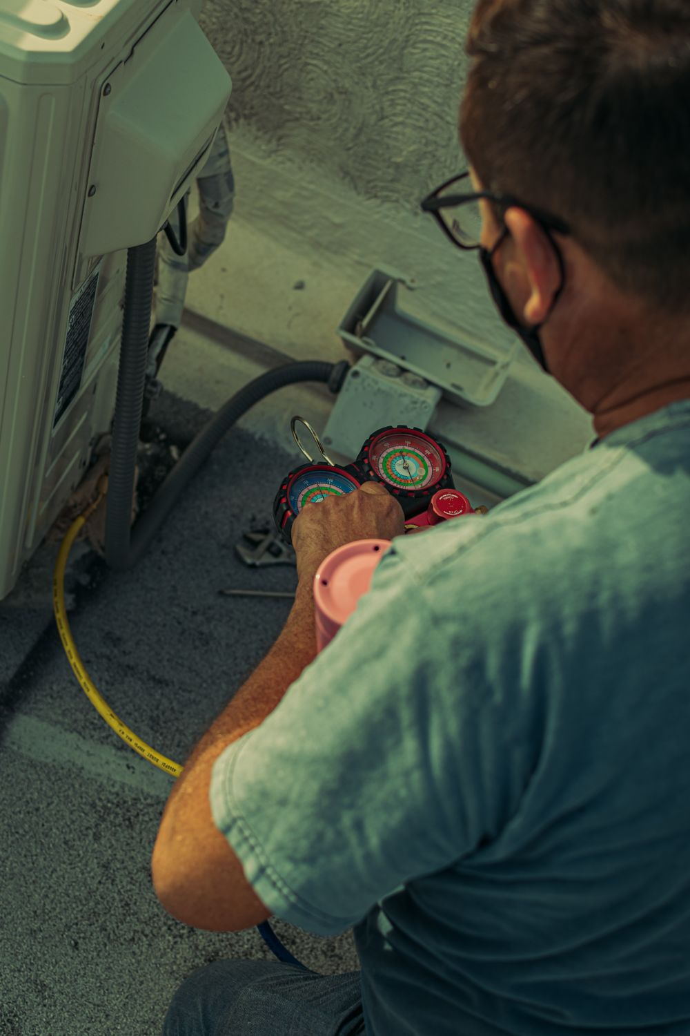 HVAC technician checking refrigerant gauges