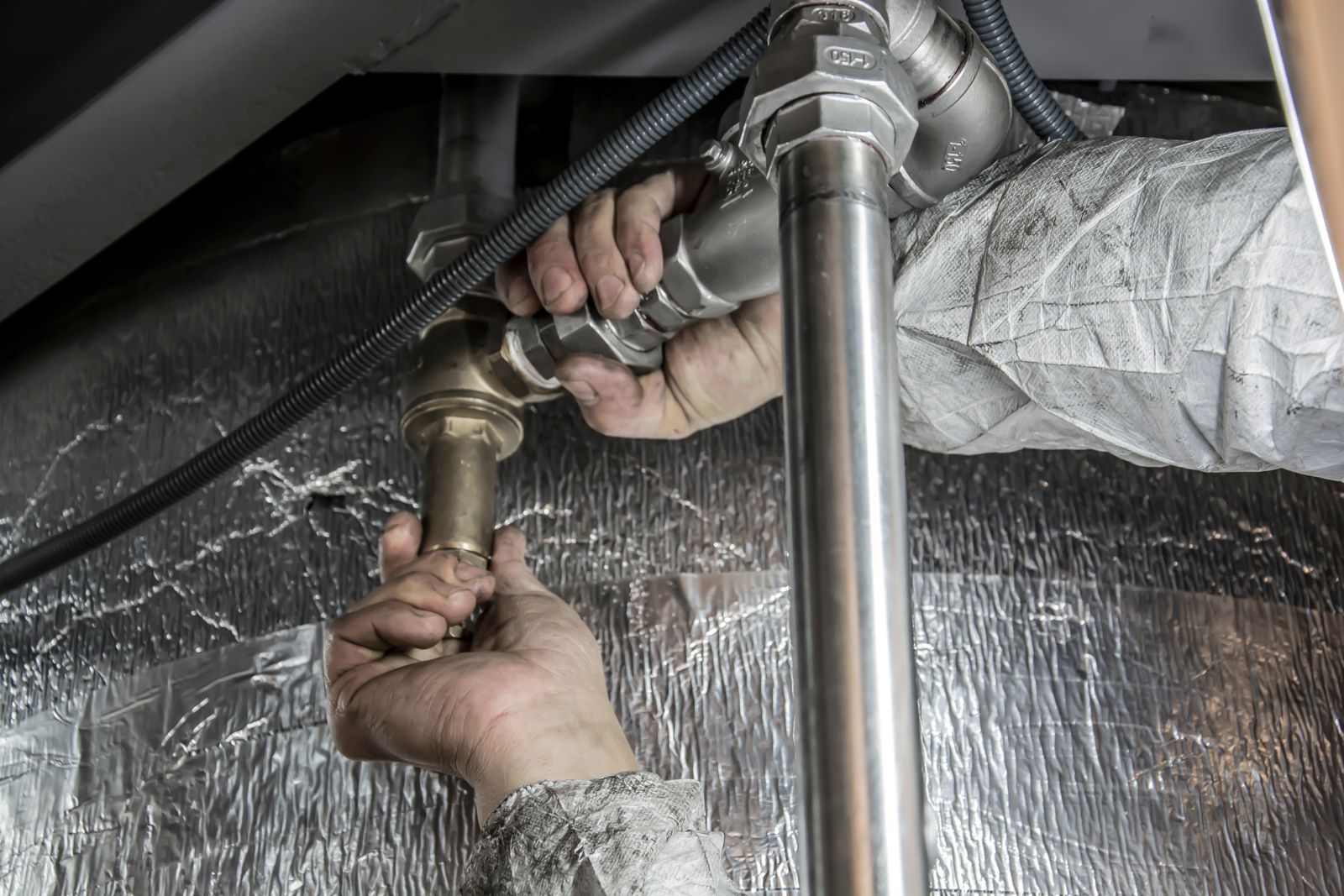 SEO for plumbers: plumber fitting pipework under a sink